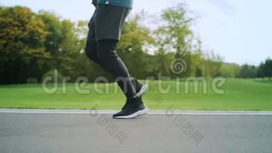 穿运动鞋的运动员在路上慢跑。 户外男子腿训练